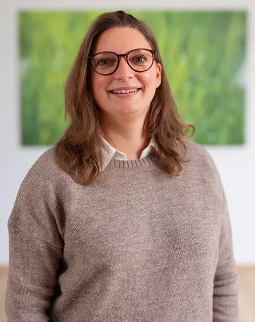 Laura Rehm in einem hellen Raum mit grünem Bild im Hintergrund