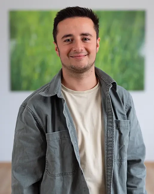 Dennis Schüttler in legerer Kleidung vor grünem Hintergrund