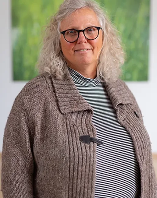 Beatrix Wehning mit gestreiftem Oberteil und brauner Strickjacke