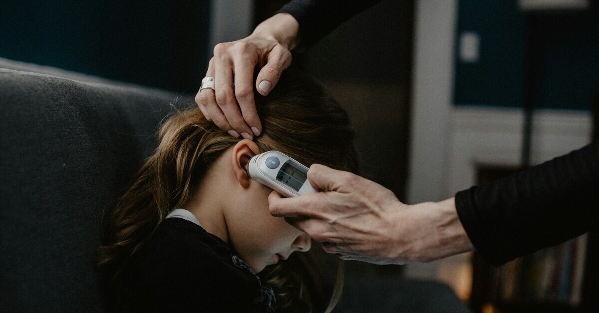 Fieber messen mit einem Ohrthermometer bei einem Kind