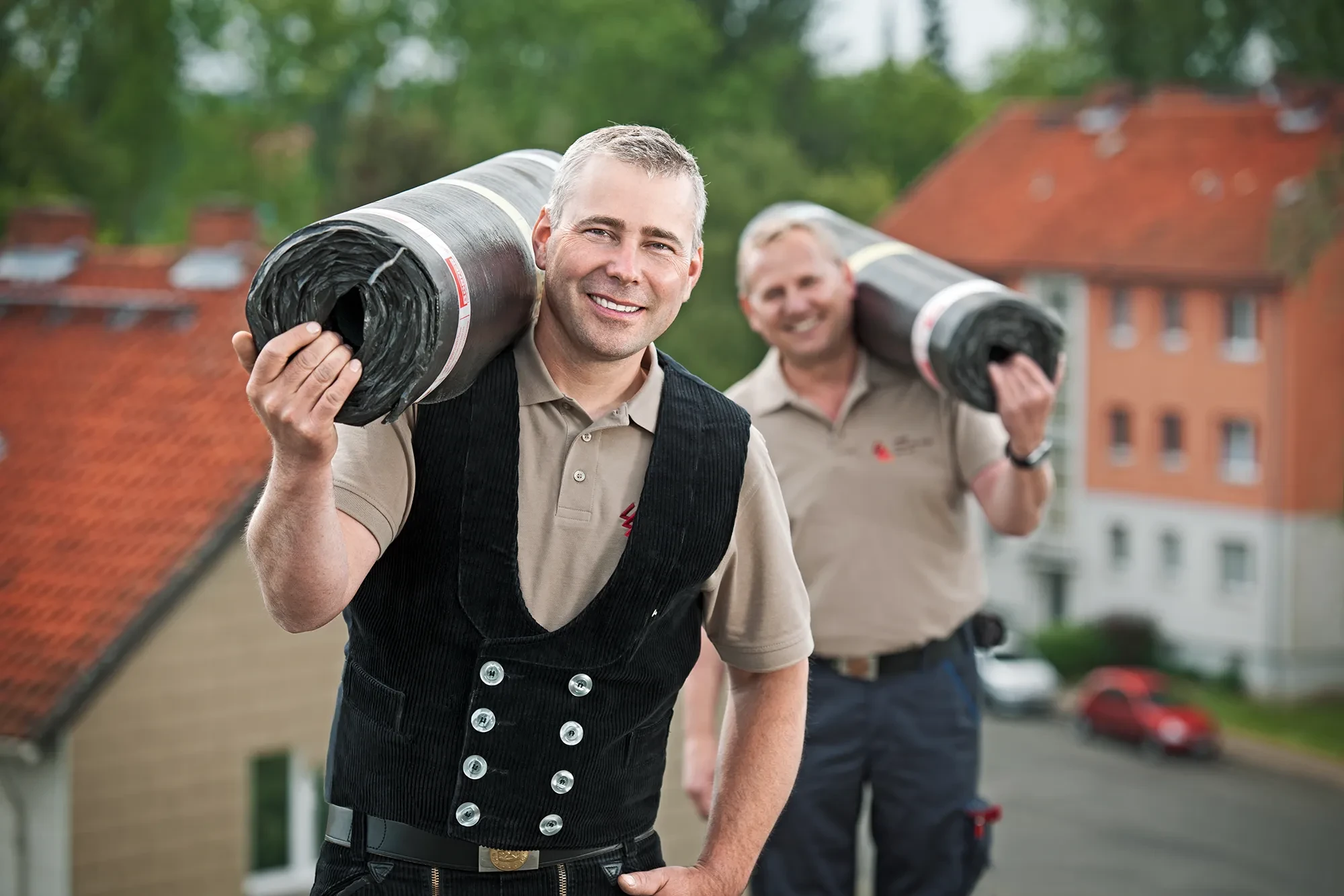 Dachdecker bei der Arbeit mit Dachbahnen auf einem Dach – professionelle Dachdeckerleistungen