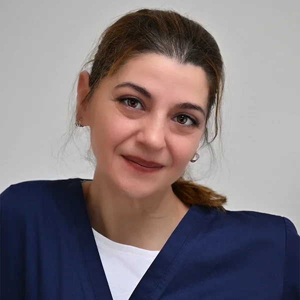 Portrait von Aygul Kirtay in medizinischer Kleidung vor neutralem Hintergrund