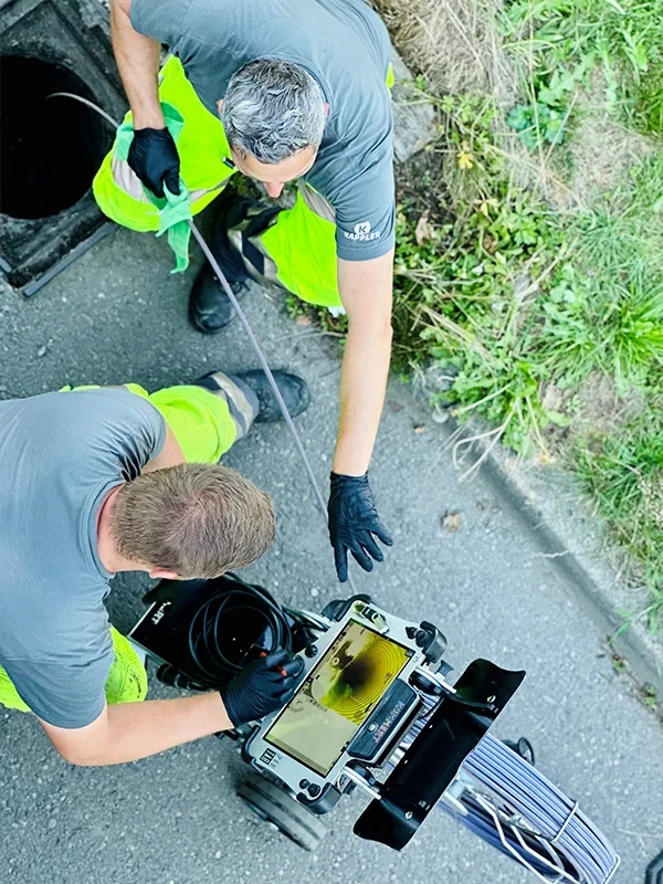 Zwei Fachkräfte führen eine Rohr- und Kanalreinigung mit moderner Kameratechnik durch