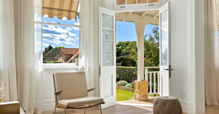 Offene Terrassentür mit Blick in den Garten und gemütlichem Sessel im Innenraum