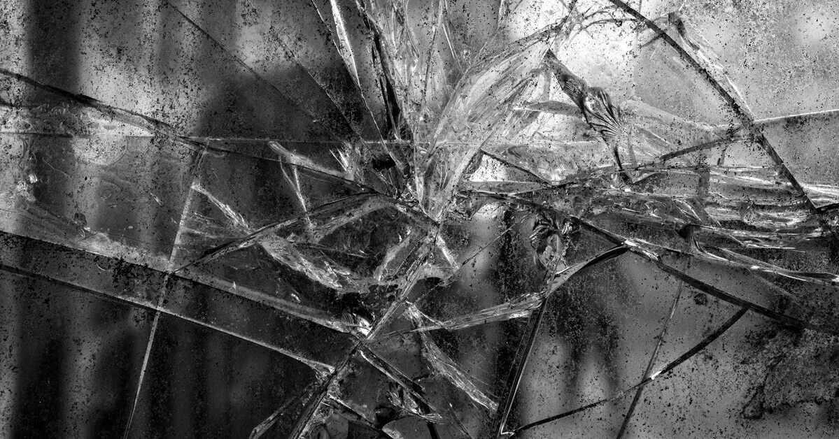 Nahaufnahme von zerbrochenem Glas mit scharfen Kanten und Rissen