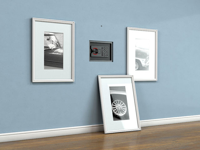 Tresoröffnung hinter Bildern an einer blauen Wand in einem Wohnzimmer