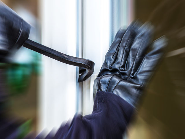 Einbruch durch ein Fenster mit Brecheisen und Handschuhen