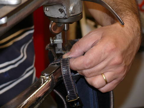 Lederarbeiten an einer Nähmaschine – Detailaufnahme einer Hand beim Nähen von Leder