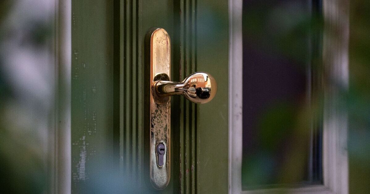 Detail einer geschlossenen Tür mit goldenem Türgriff und Schloss