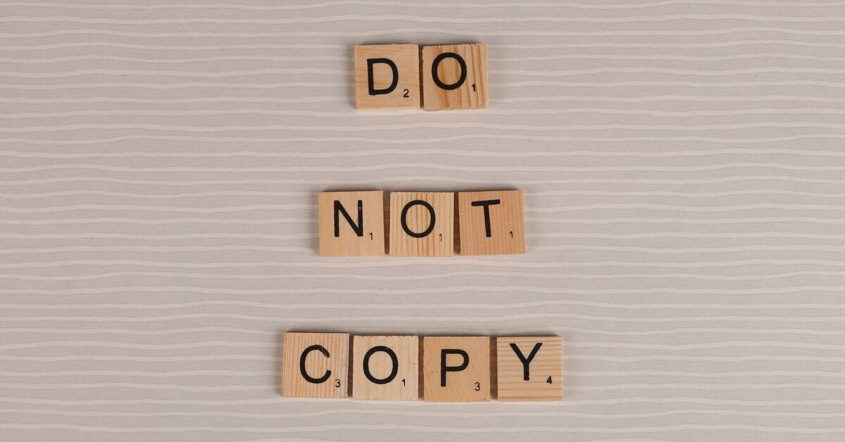 Kopierverbot: Holzbuchstaben bilden den Schriftzug 'Do not copy' auf hellem Hintergrund