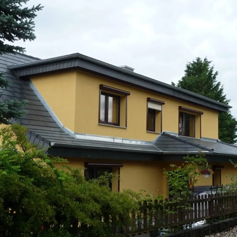 Modernes gelbes Wohnhaus mit Satteldach und Garten