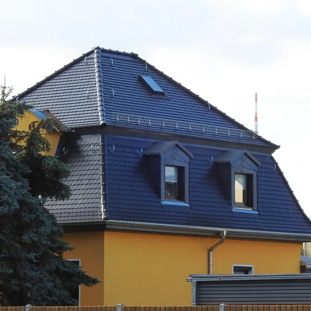 Modernes gelbes Einfamilienhaus mit dunklem Dach und Gauben, Seitenansicht