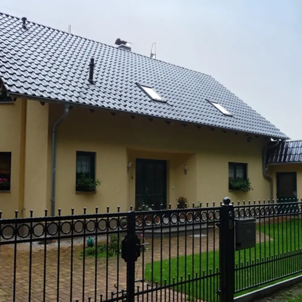 Modernes Einfamilienhaus mit Garten und Metallzaun, quadratisches Contentbild