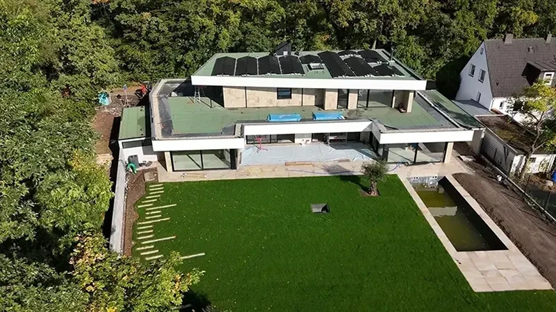 Moderne Gartengestaltung Referenzen – Beispiel für einen gepflegten Garten mit Rasen und moderner Architektur