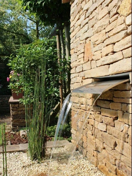 Natursteinarbeiten Referenzen: moderner Gartenbrunnen mit Natursteinmauer und Wasserlauf