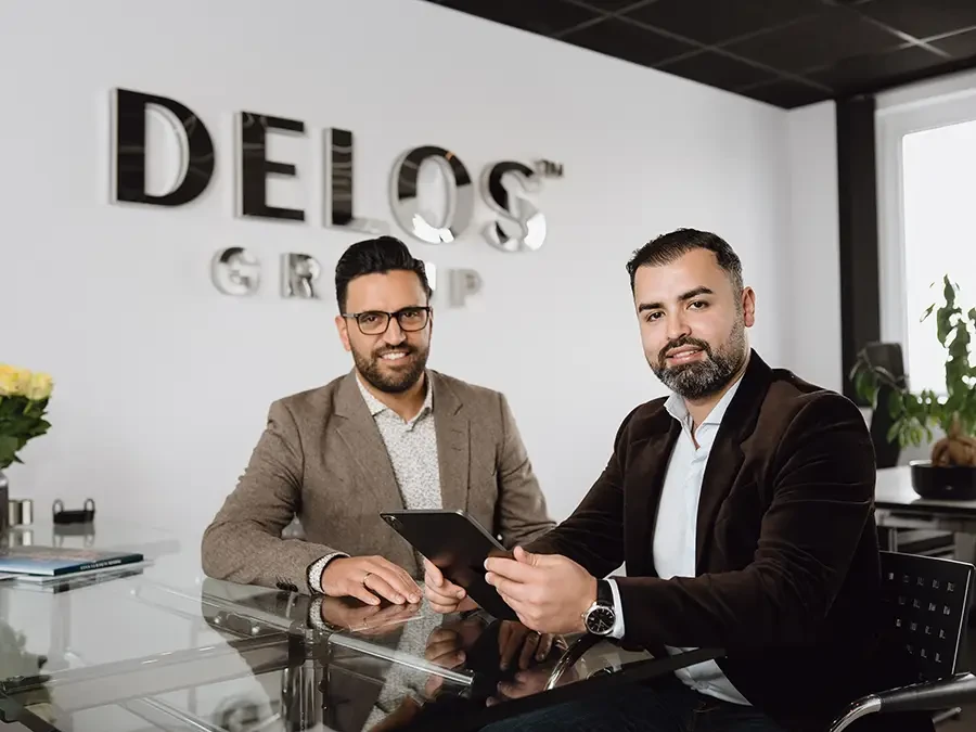 Geschäftstreffen bei DELOS GROUP mit zwei Männern am Konferenztisch