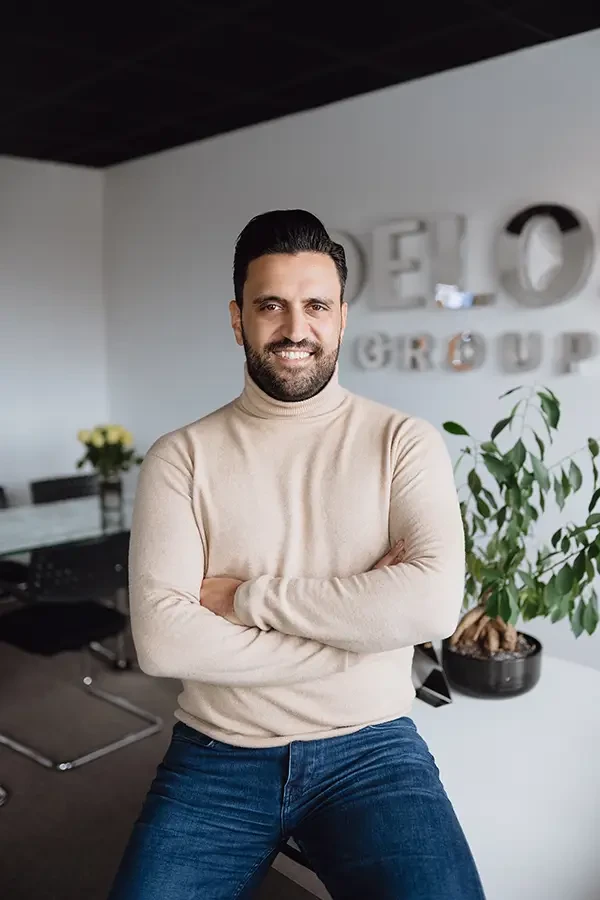 Mann mit beigem Rollkragenpullover im modernen Büro der Delo Group