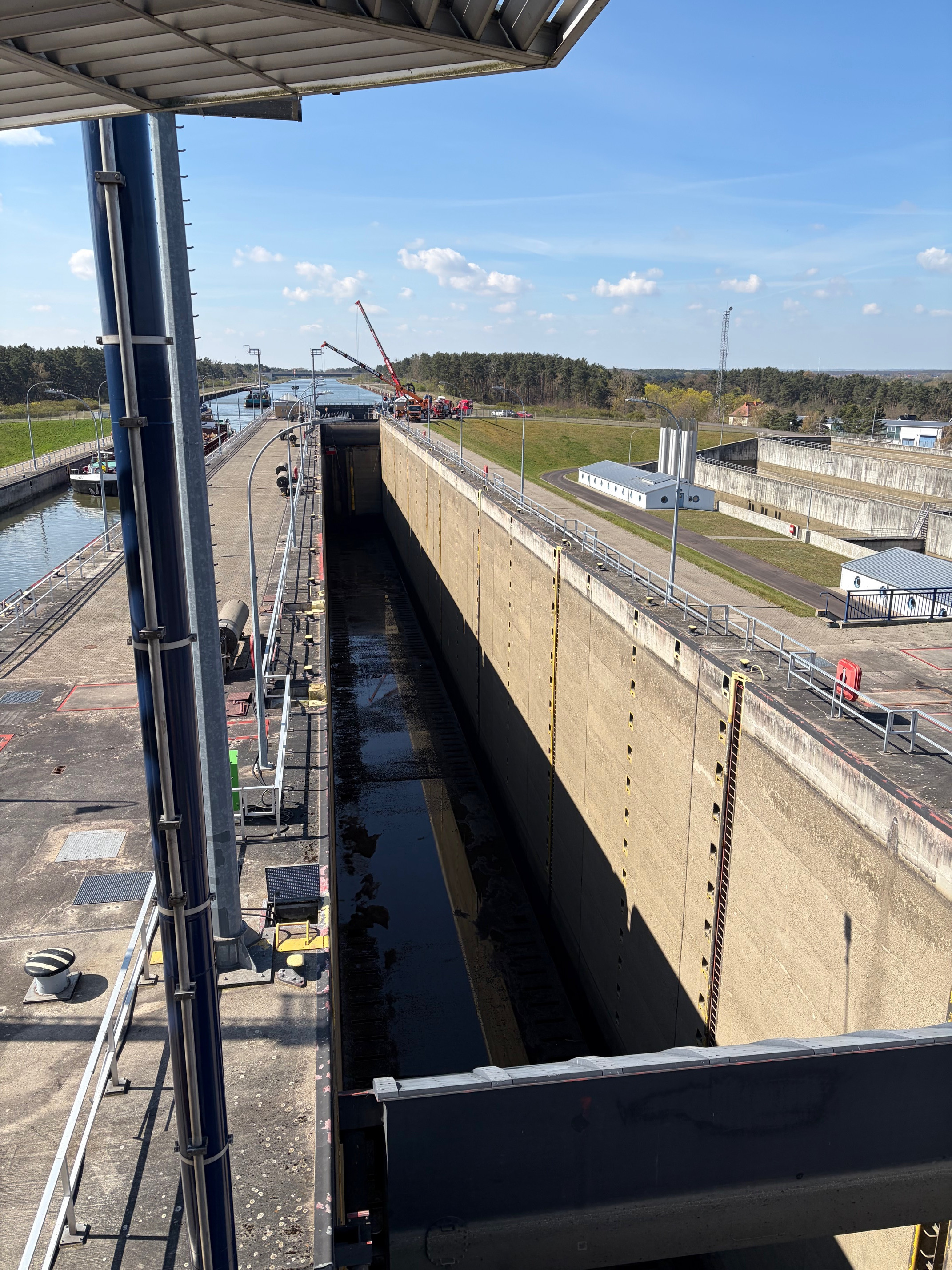 Blick auf eine große Schleuse mit Bauarbeiten und Kran bei sonnigem Wetter