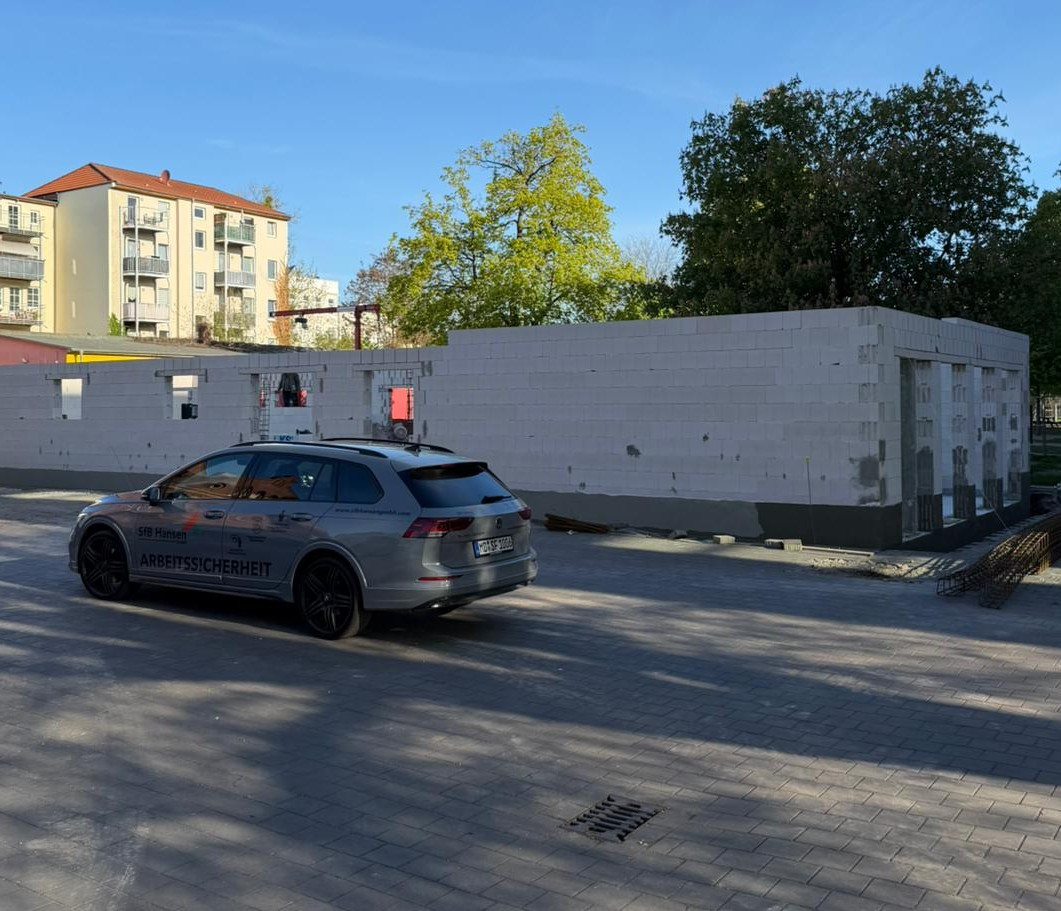 Baustelle der Grundschule Sudenburg mit Fahrzeug der Arbeitssicherheit im Vordergrund