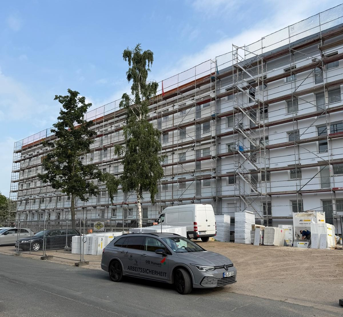 Sanierung eines Mehrfamilienhauses in der Ulnerstraße mit Baugerüst und Sicherheitsfahrzeug
