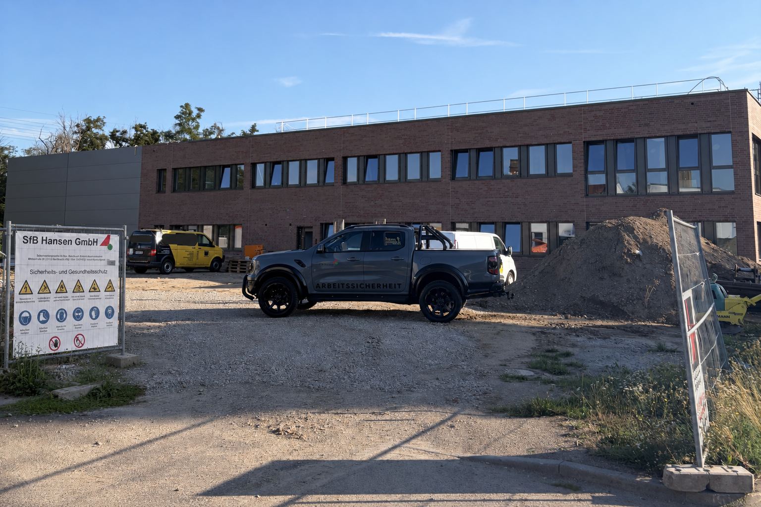 TWM Funktionsgebäude im Rohbau mit Fahrzeugen für Arbeitssicherheit auf der Baustelle
