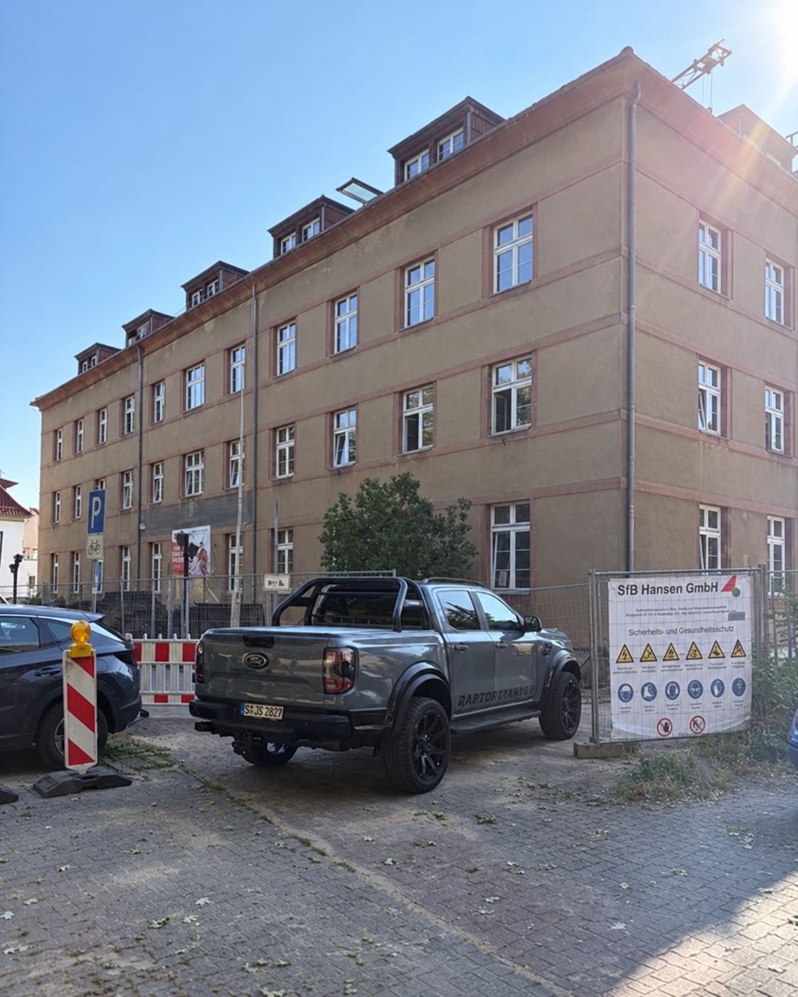 DRK WMS Gebäude mit Bauzaun und geparktem Ford Raptor vor dem Eingang