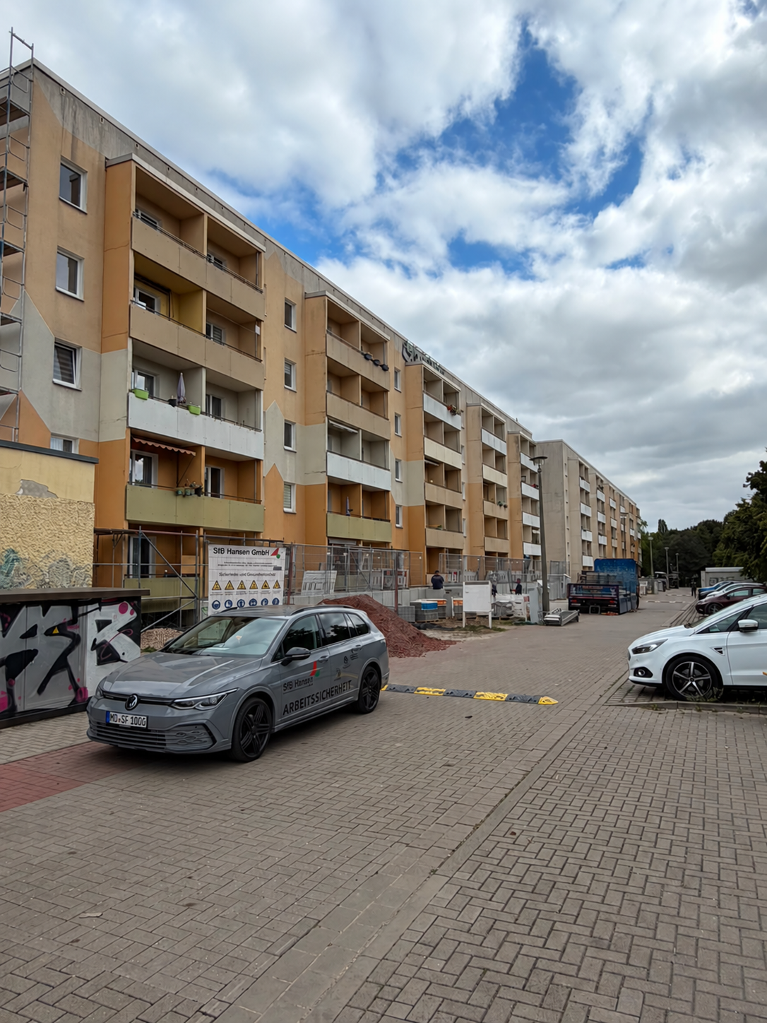 Mehrfamilienhaus an der Uelnerstraße mit Baustelle und geparkten Autos