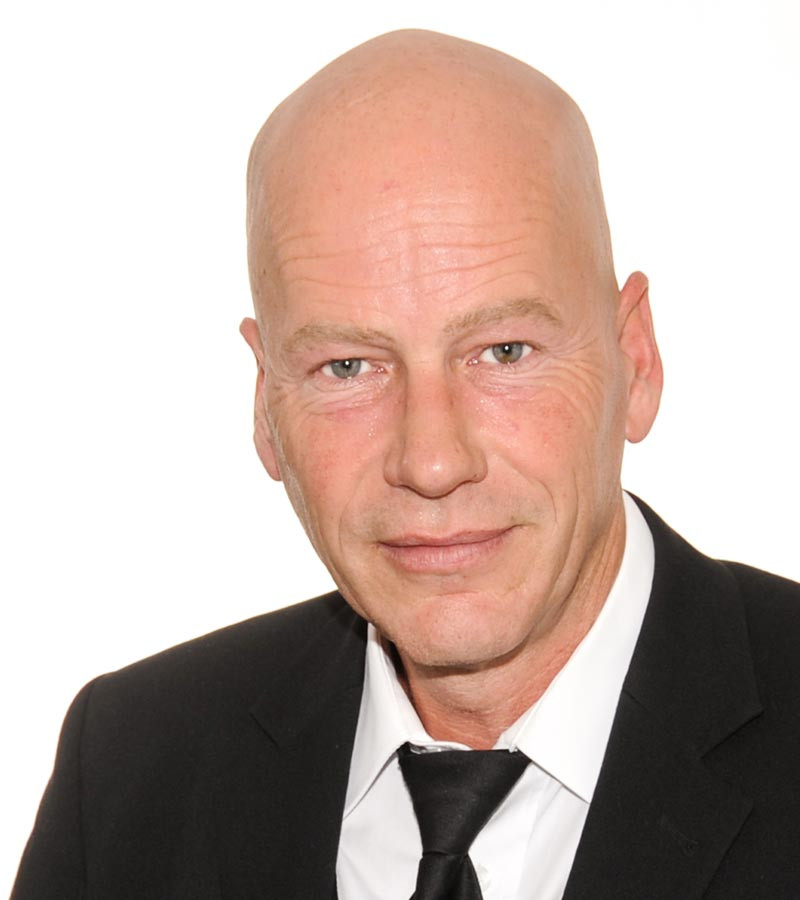 Stefan Zander im Anzug vor weißem Hintergrund