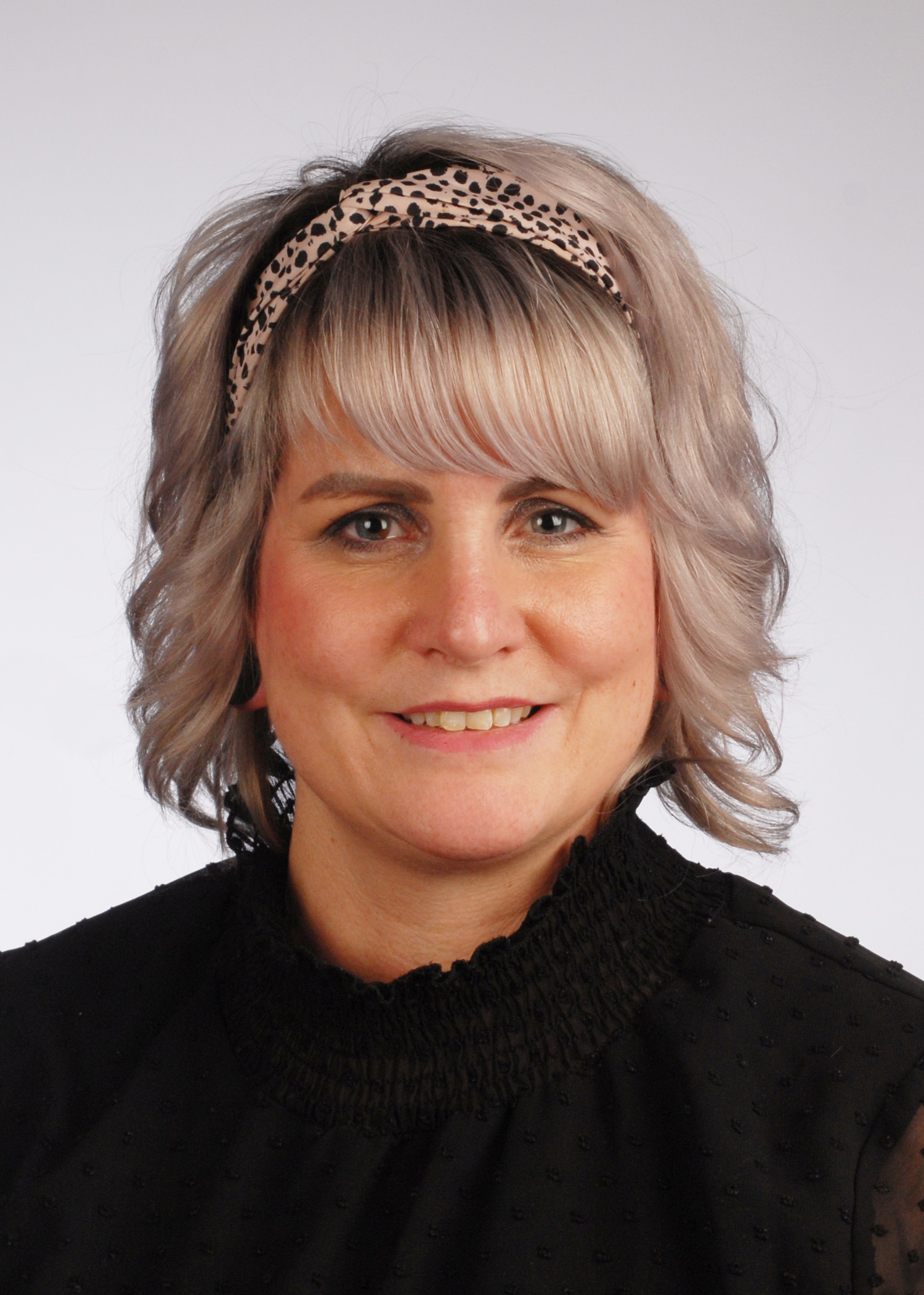 Porträtfoto von Kathrin Knoll mit blondem, gewelltem Haar und Haarband