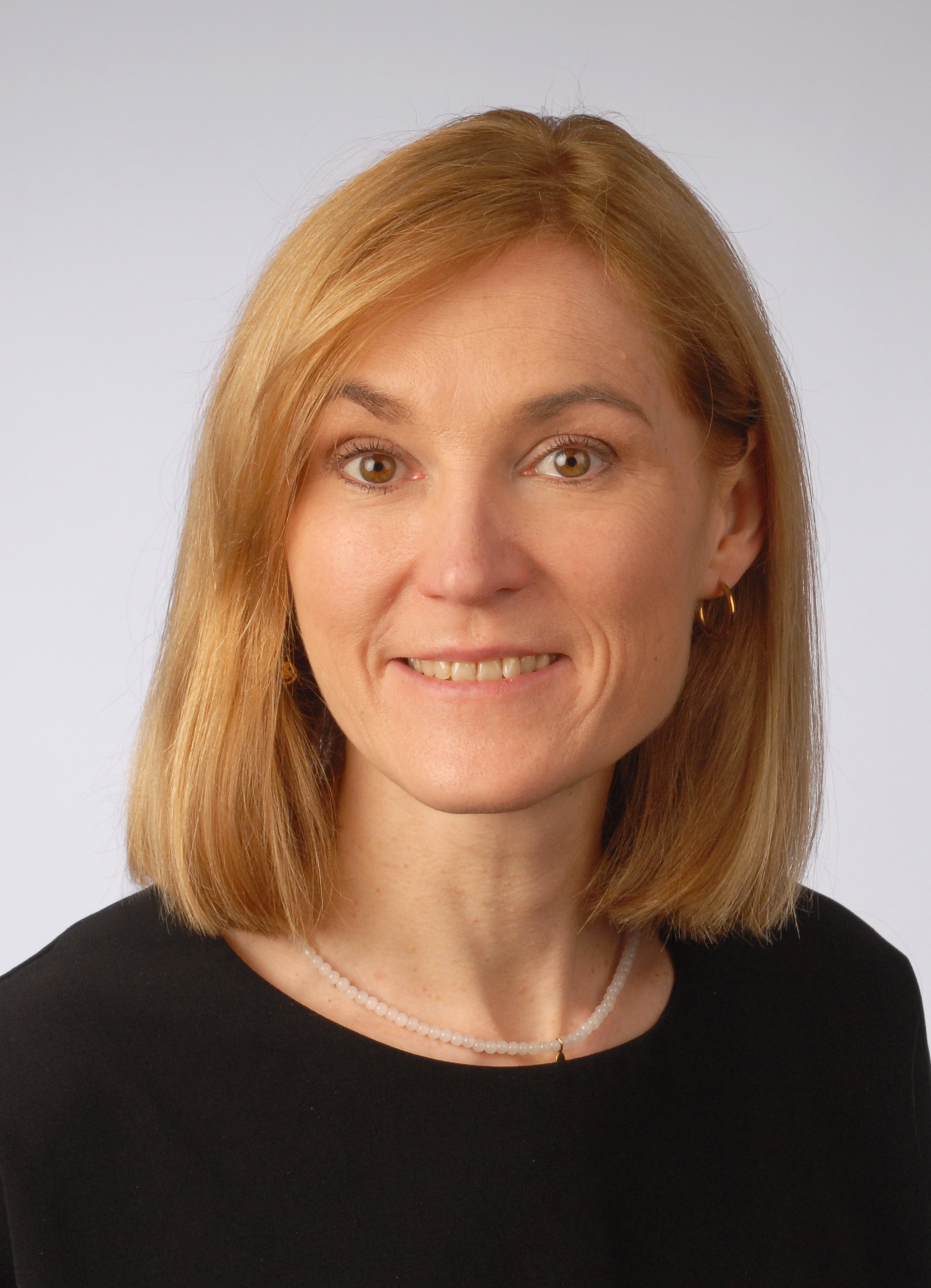 Porträtfoto von Alexsandra mit blonden Haaren und schwarzem Oberteil