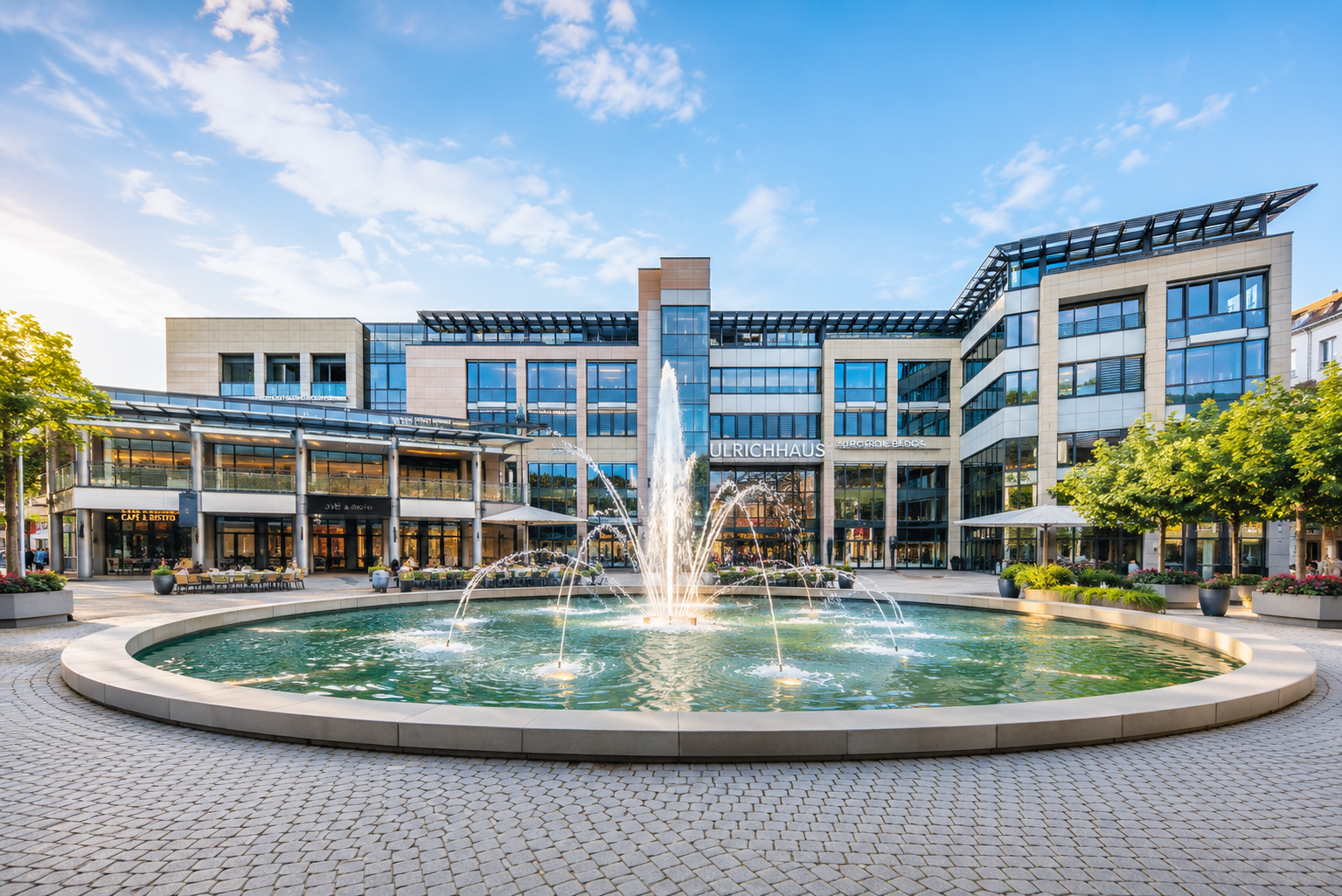 Moderner Bürokomplex Ulrichhaus mit Springbrunnen am 30. Juli 2026 bei blauem Himmel