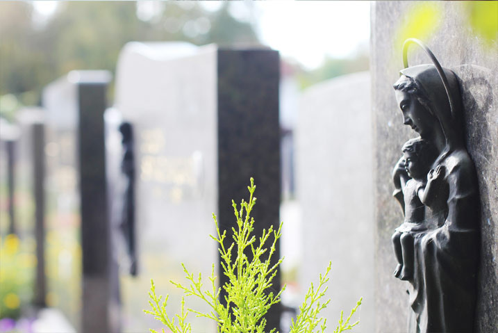 Teaser-Leistungen – Grabstein mit Engelsfigur und Pflanze auf einem Friedhof
