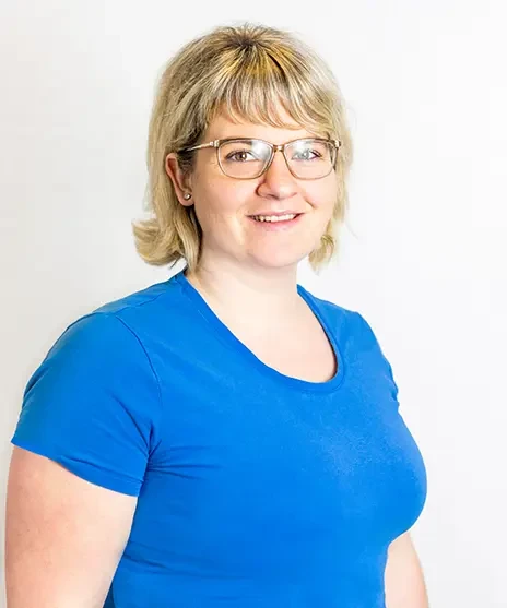 Frau mit blonden Haaren in blauem T-Shirt vor weißem Hintergrund