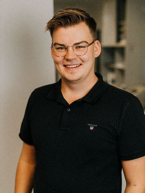 Bennet Hunger in schwarzem Poloshirt vor unscharfem Hintergrund