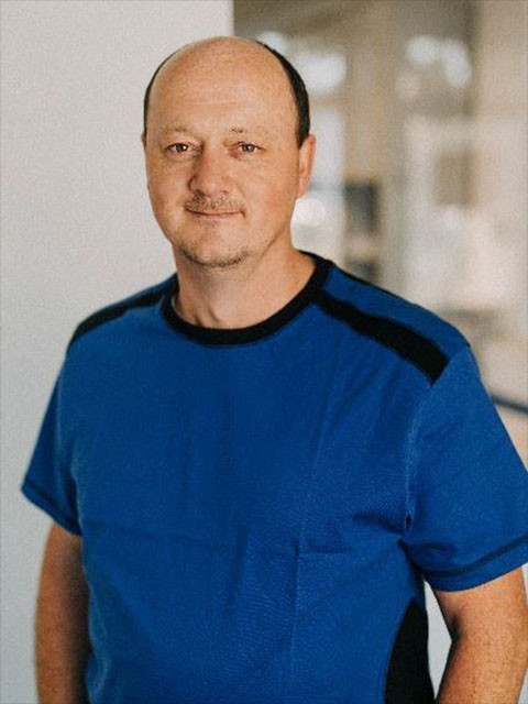 Jakob Block mit blauem T-Shirt in einem modernen Innenraum