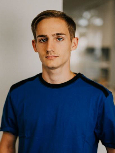 Paul Schmid in blauem T-Shirt vor unscharfem Hintergrund