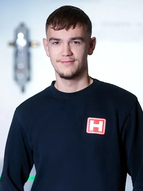 Jonathan Hieb mit schwarzem Pullover und H-Logo