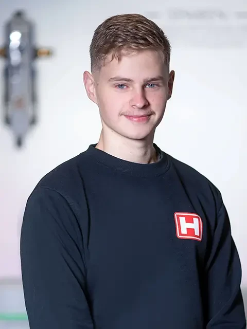 William Reger mit schwarzem Pullover und rotem H-Logo