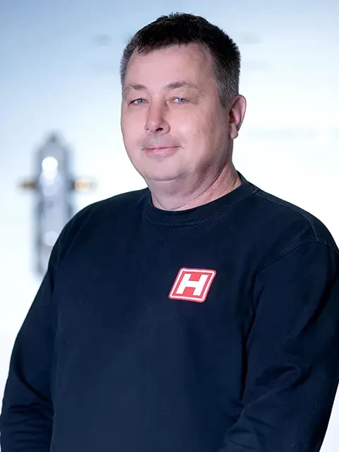Alexander Heidenreich mit schwarzem Pullover und rotem H-Logo