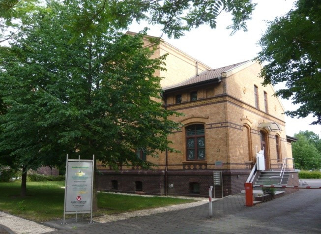 Backsteingebäude L22 mit Bäumen und Eingang