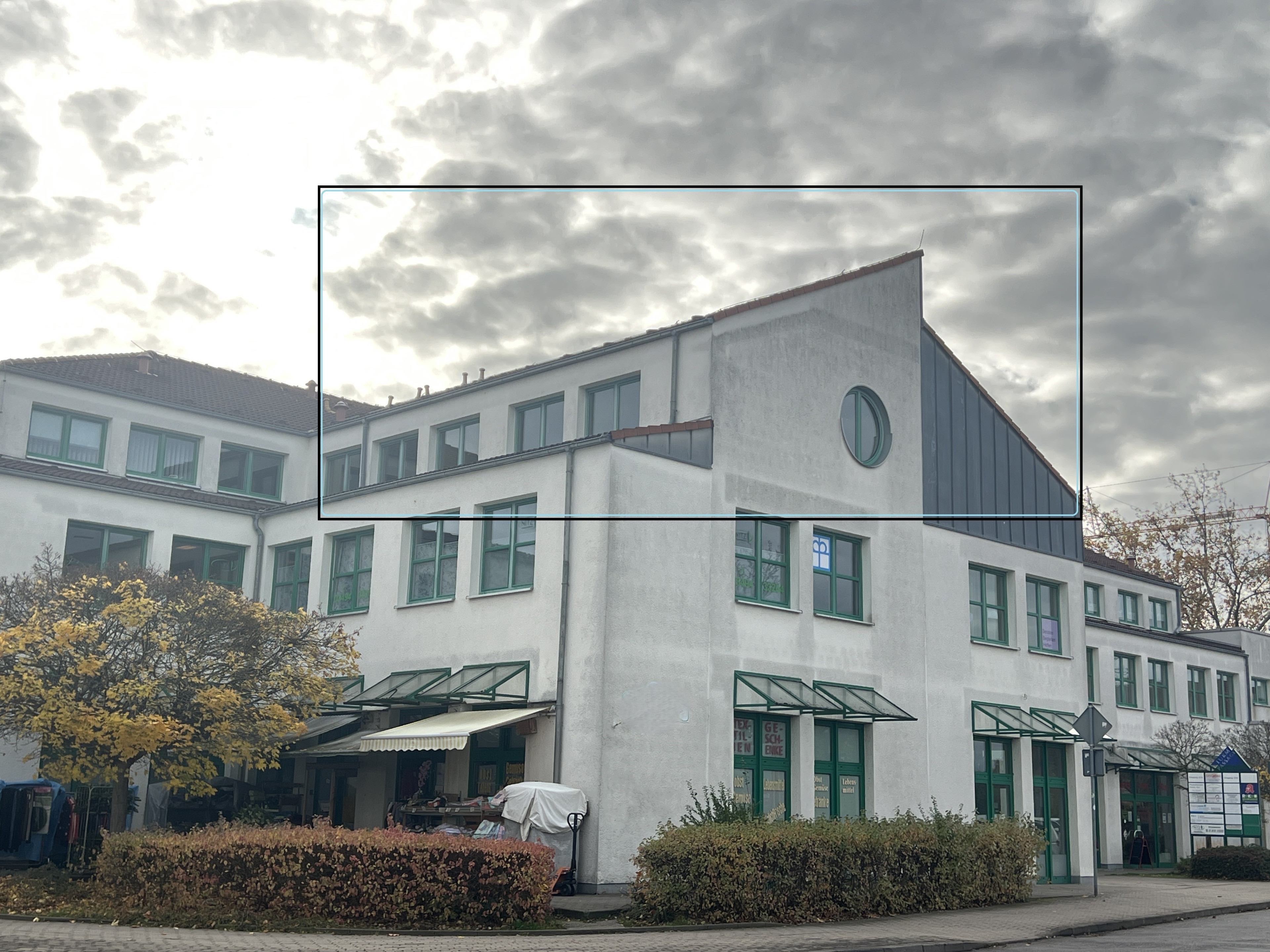 Gebäude mit eingezeichnetem Rechteck auf der Fassade, moderne Architektur mit grünen Fensterrahmen