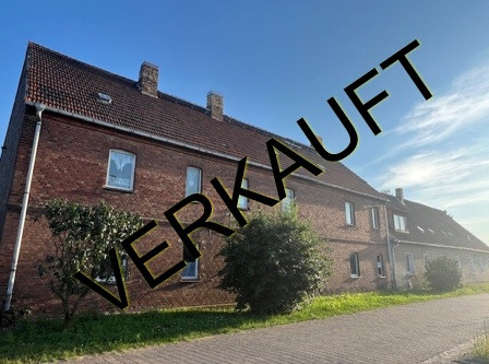 Verkauftes Wohnhaus in Prussendorf am Teich mit Backsteinfassade und blauem Himmel