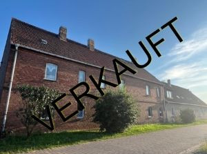 Verkauftes Mehrfamilienhaus in Prussendorf am Teich mit Backsteinfassade und Vorgarten