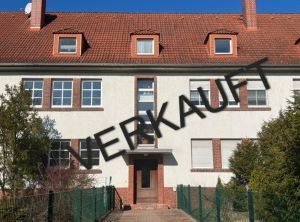 Mehrfamilienhaus mit verkauft-Schriftzug auf der Fassade