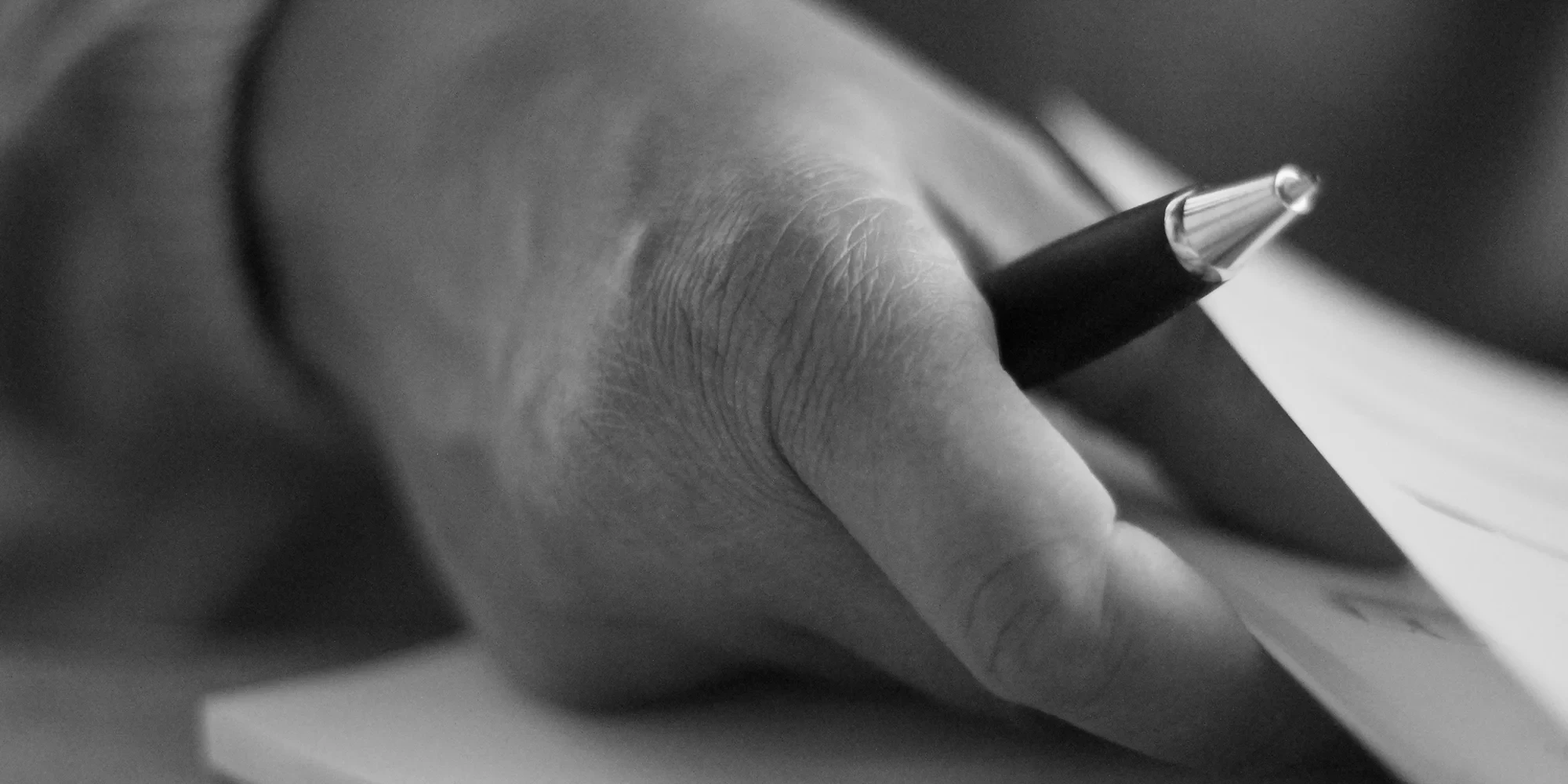 Hand unterschreibt Dokument zur Bestattungsvorsorge – Symbolbild für Bestattungsvorsorge neu