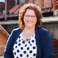 Melanie Kahle Melanie Kahle lächelnd vor einem Gebäude