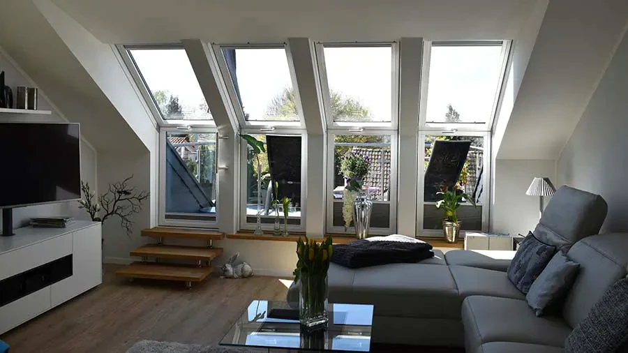 Wohnraum mit großen Dachfenstern und moderner Einrichtung