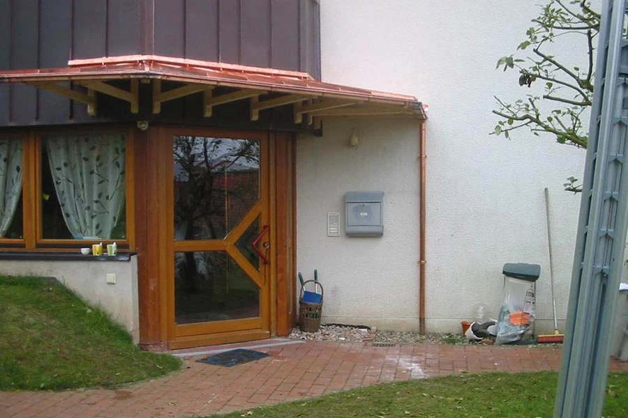 Vordach über einem Hauseingang mit Holztür