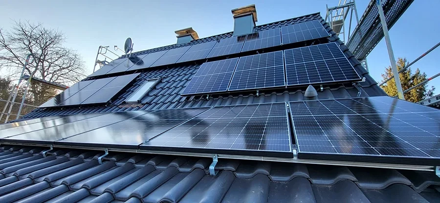 Solarpaneele auf einem Ziegeldach bei klarem Himmel