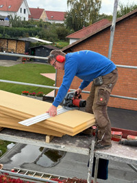 Gorden bei der Arbeit auf einer Baustelle – Zuschneiden von Dämmplatten mit Kreissäge Gorden arbeitet mit einer Kreissäge auf einer Baustelle und schneidet Dämmplatten zurecht.